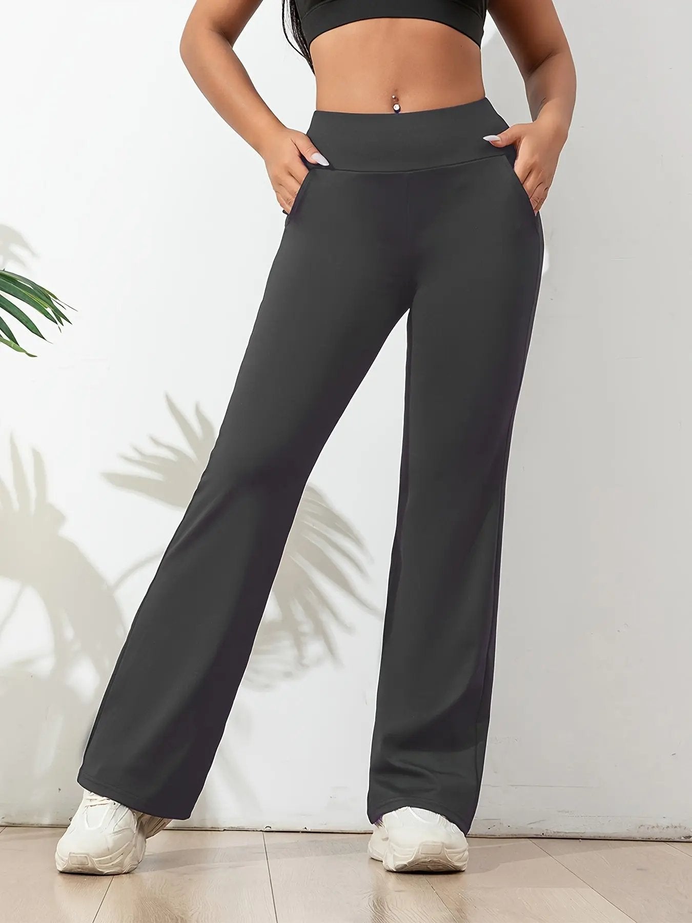 Women's black high waisted yoga pants with wide waistband, four-way stretch, and side pockets