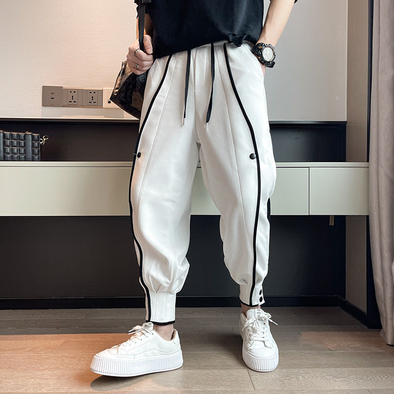 Black tapered joggers streetwear style elastic waistband with ankle button details for men