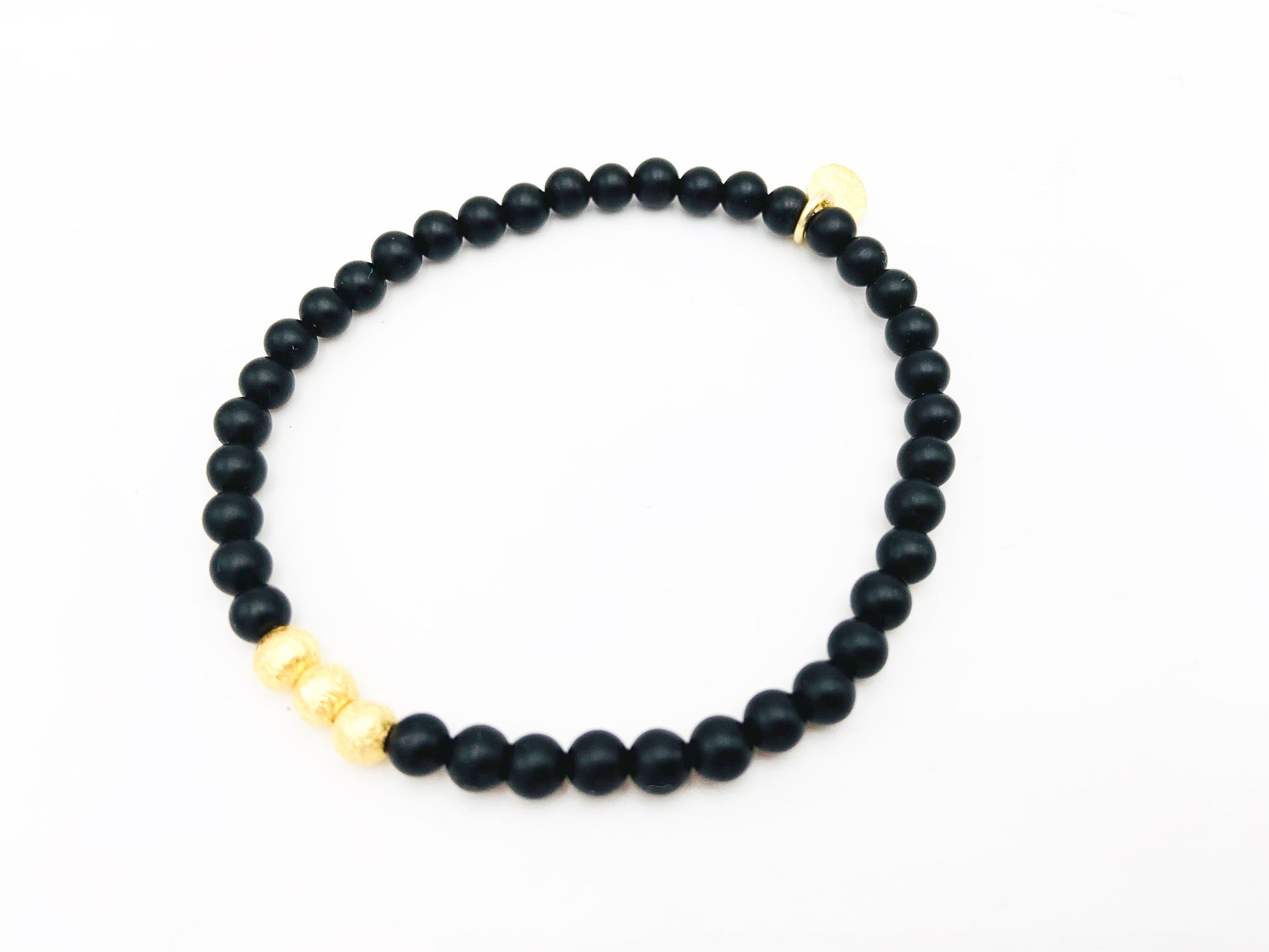 Minimalist women's matte onyx bead bracelet with brushed sterling silver disc accent for elegant layering
