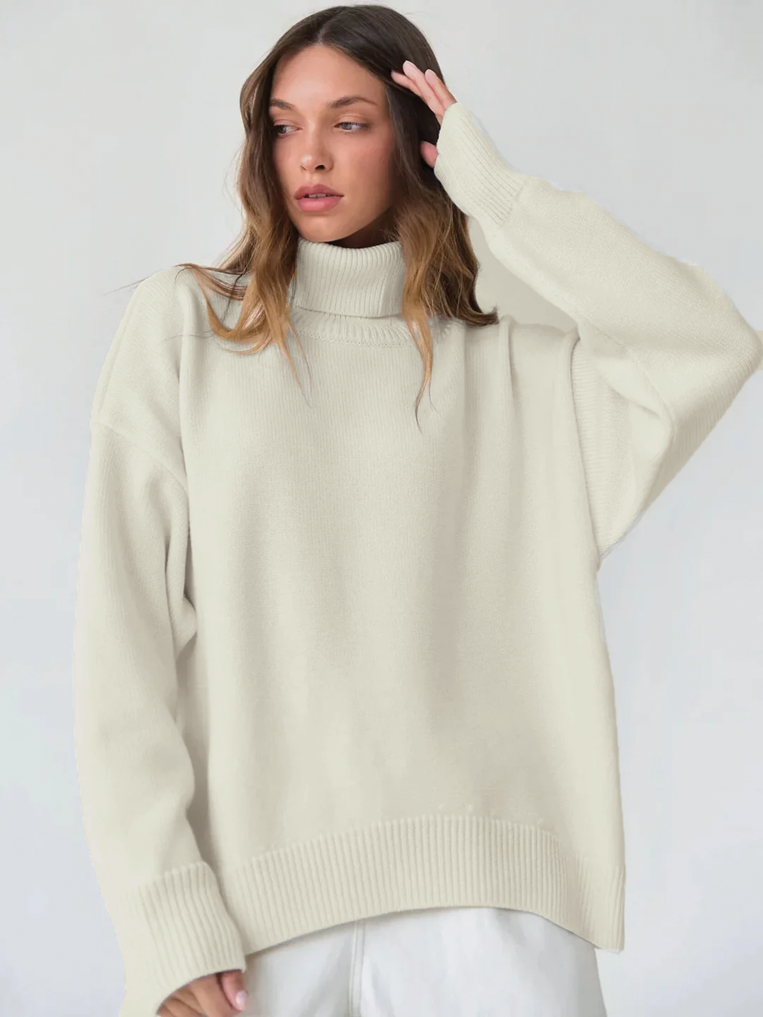 Women's oversized ivory knit turtleneck sweater with ribbed detail and relaxed cozy silhouette