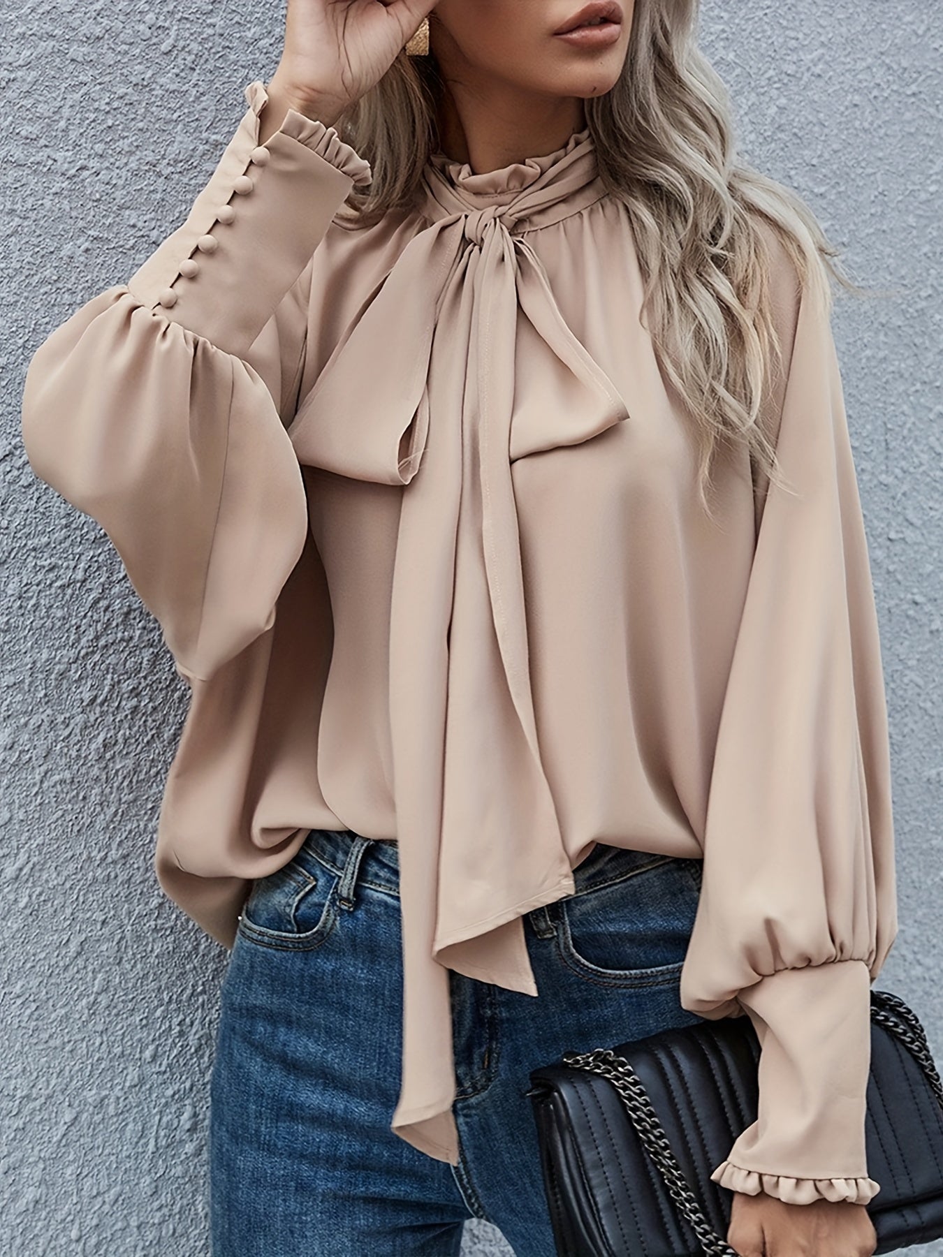 Women's elegant white tie-neck blouse with long sleeves and structured bow detail for office wear