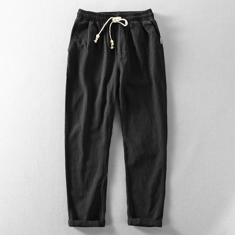 Men's taupe linen blend tapered trousers with elastic waistband and ankle-length silhouette