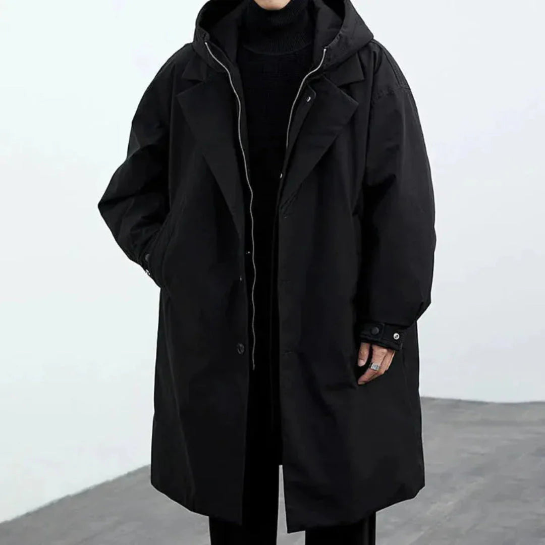 Black longline winter jacket with detachable hood, layered front closure, weatherproof city commuter style