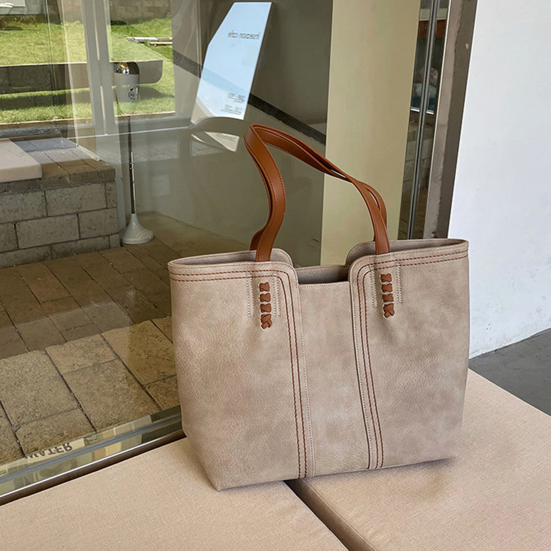 Black PU leather women's tote bag with elegant inner compartments and zipper closure