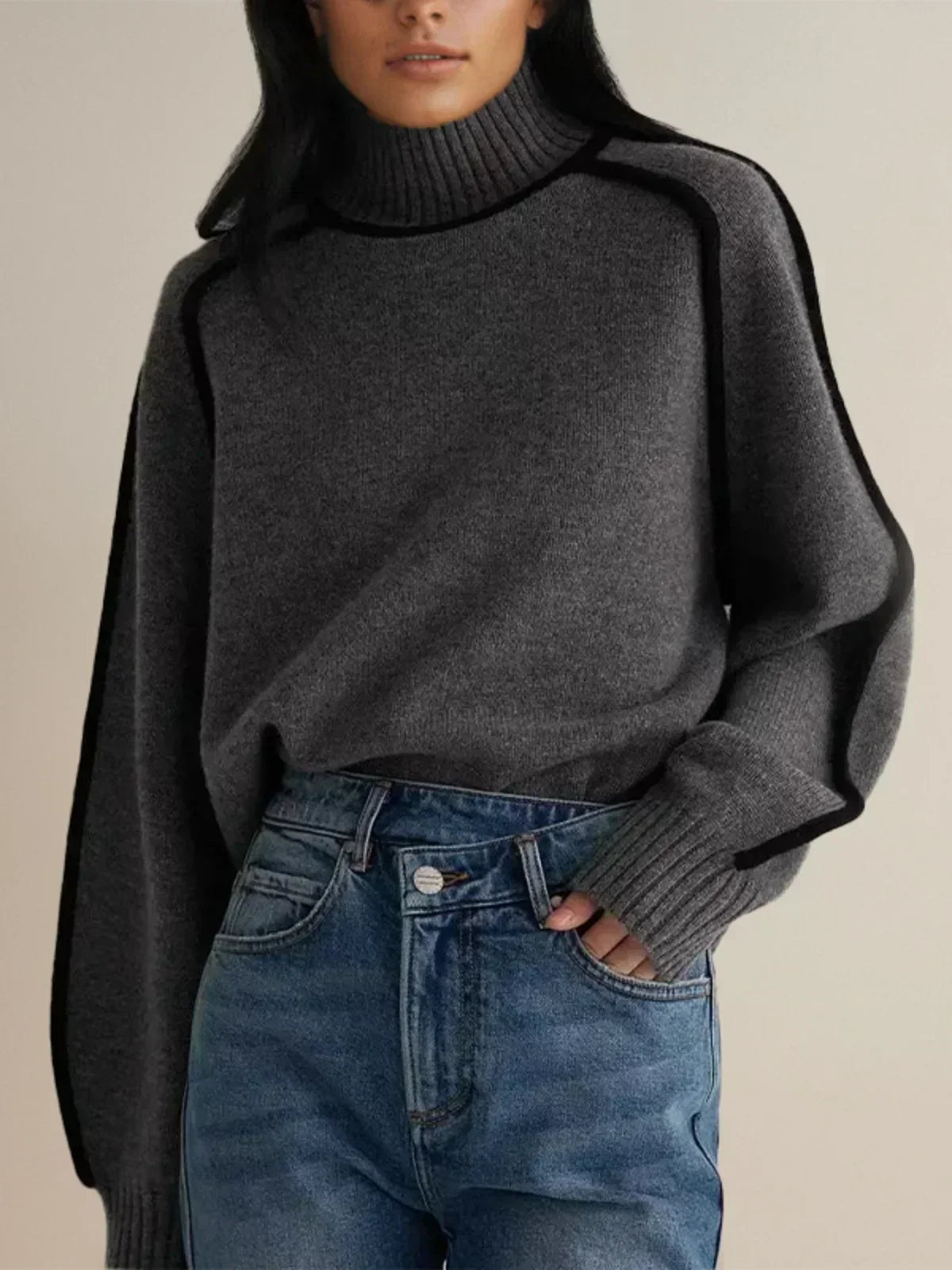 Ivory knit turtleneck sweater with black contrast trim seams, sleek architectural cut for professionals
