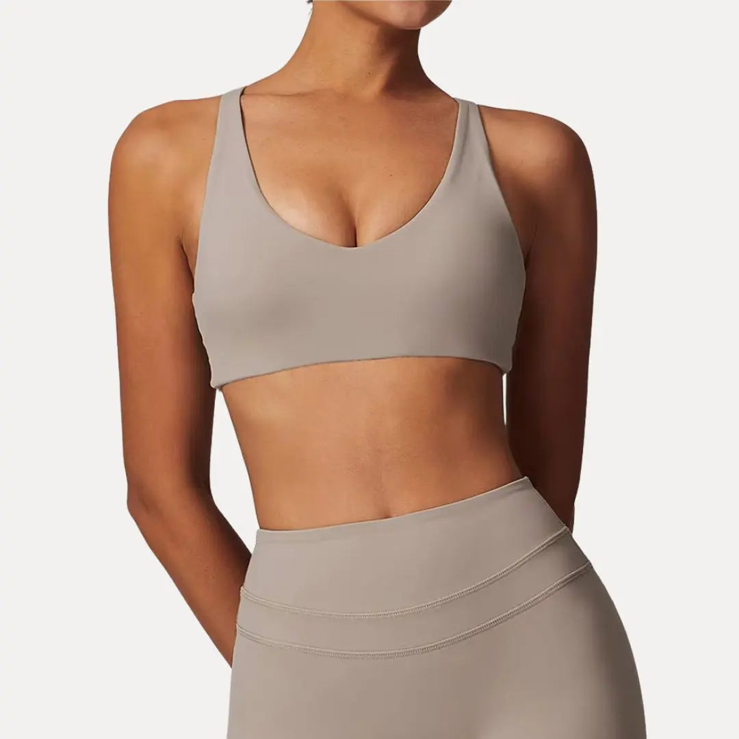 Lyra black sports bra with adjustable crisscross back straps, light support, breathable minimalist fit