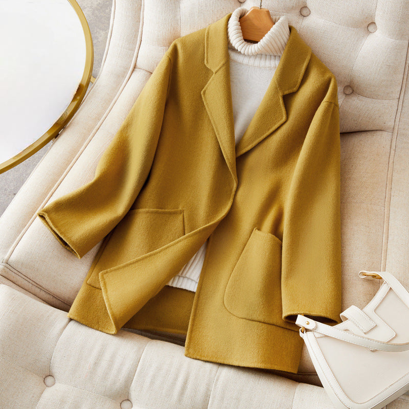 Women's relaxed fit mid-thigh wool coat in neutral tone with effortless silhouette and premium warmth