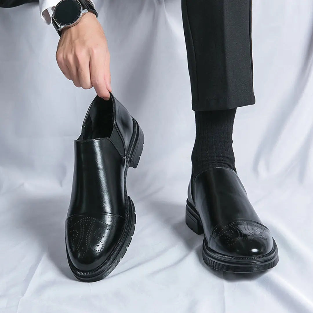 Men's polished leather loafers in black with classic cap toe and subtle brogue accents slip-on