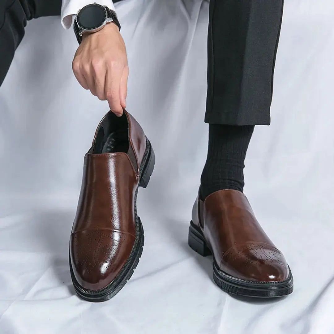 Men's polished leather loafers in classic black with sleek cap toe and subtle brogue accents