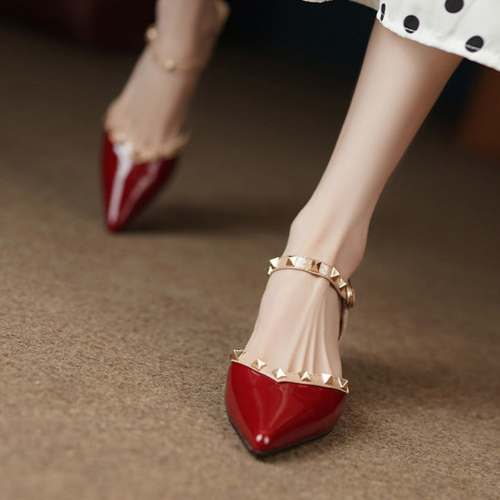 Women's black patent glossy pointed-toe block heel pumps with studded edge detailing