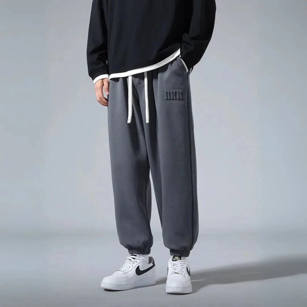Men's relaxed fit cotton joggers with brushed fleece interior, minimalist streetwear style in neutral tone