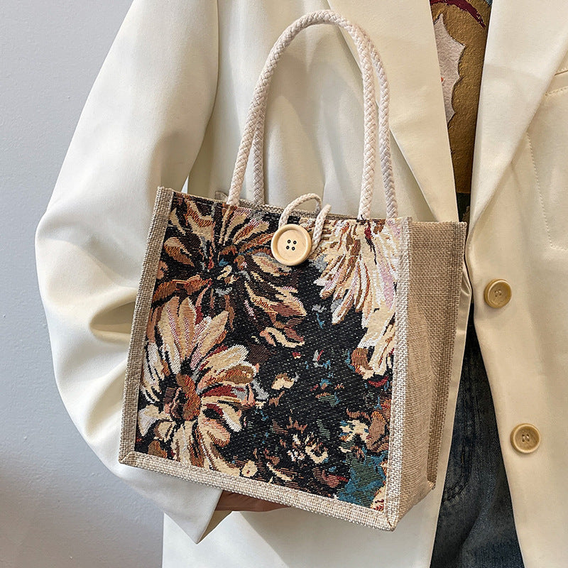 Heather floral woven tote bag in blooming colors, boxy twill silhouette with bold button and double straps