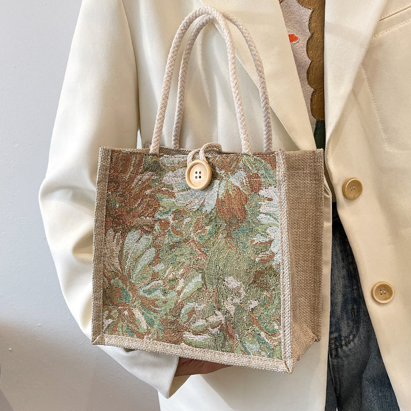 Heather floral woven tote bag in blooming colors, boxy twill silhouette with bold button and double straps