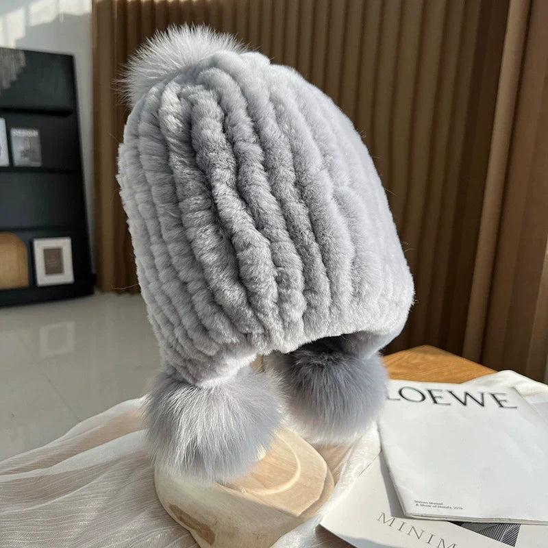 Women's ribbed knit beanie hat in cozy style with fur trim pompoms for chic winter warmth