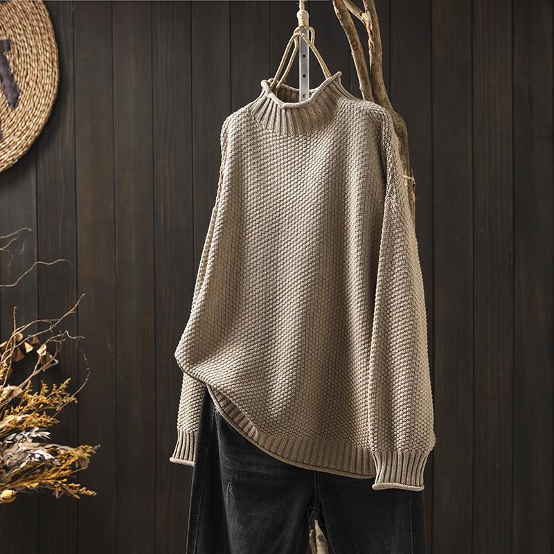 Cream waffle-knit turtleneck sweater with dropped shoulders and structured texture for relaxed layering