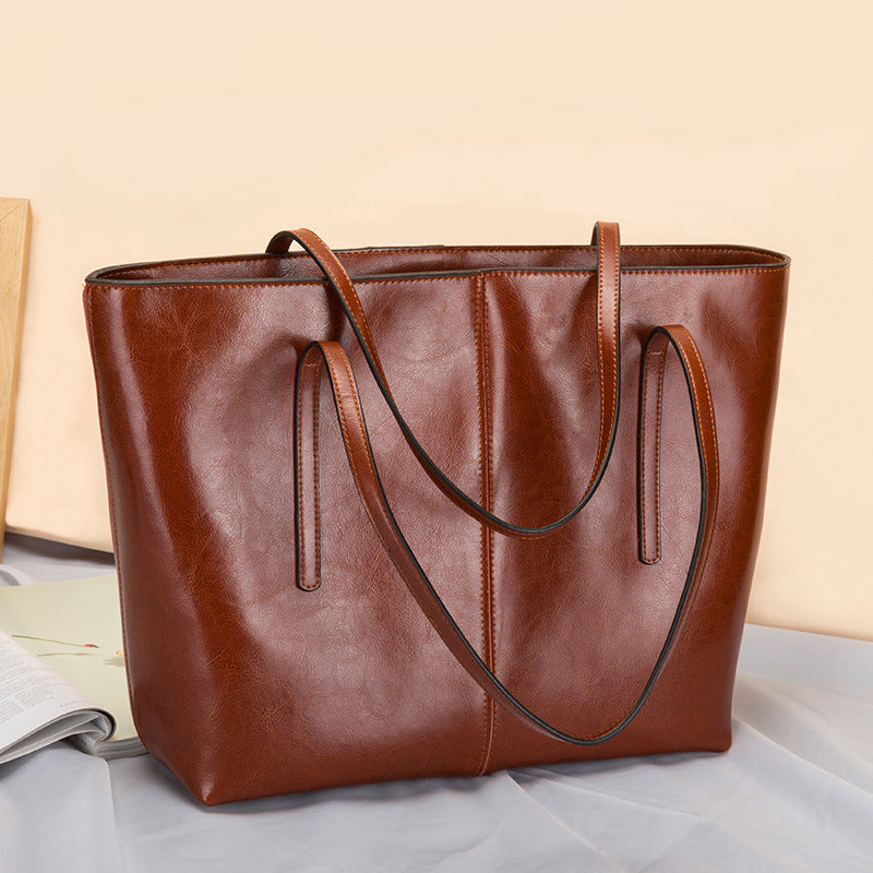 Andrea structured leather tote bag smooth texture slim straps spacious open-top interior everyday use