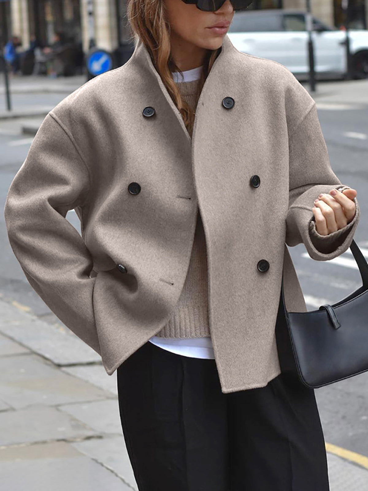 Women's black double-breasted tailored coat with classic button detailing and structured silhouette