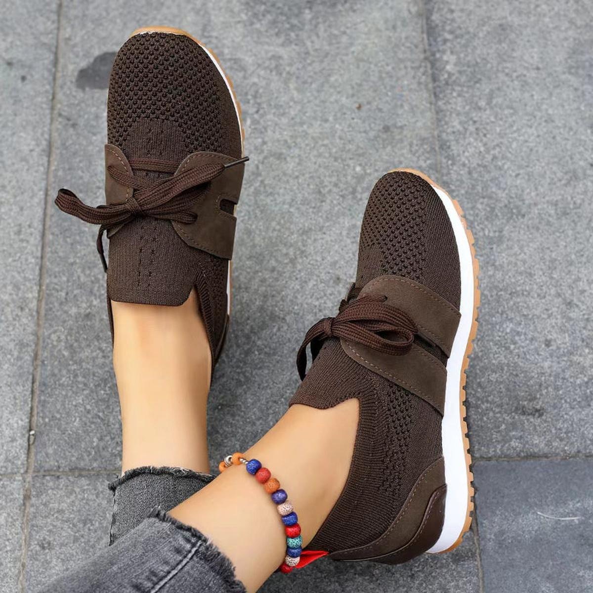 Women's black breathable knit mesh sneakers with flexible sole and feminine bow-style lace detail