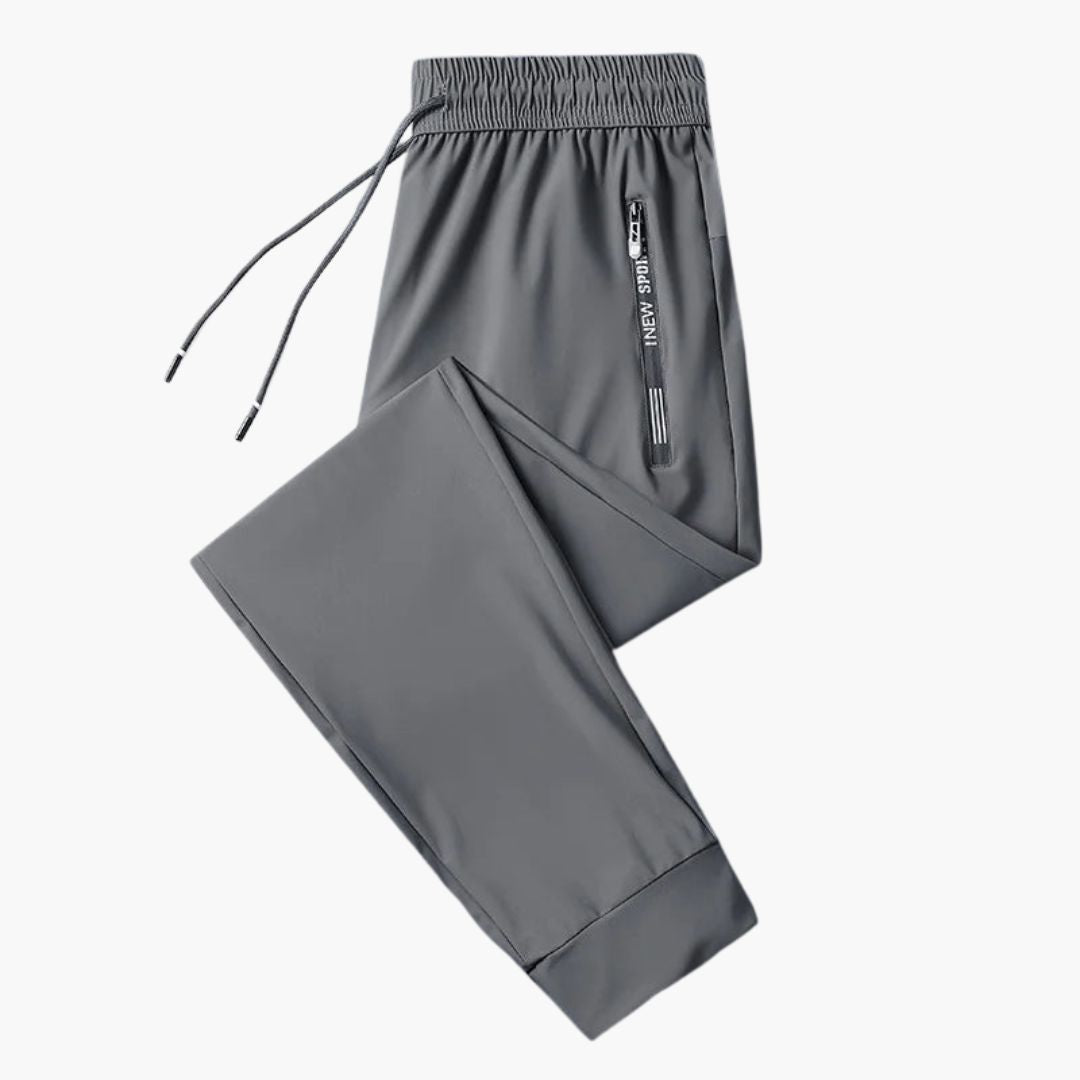 Men's slim-fit jogging pants with elastic waistband, zipped pockets, in neutral athletic style