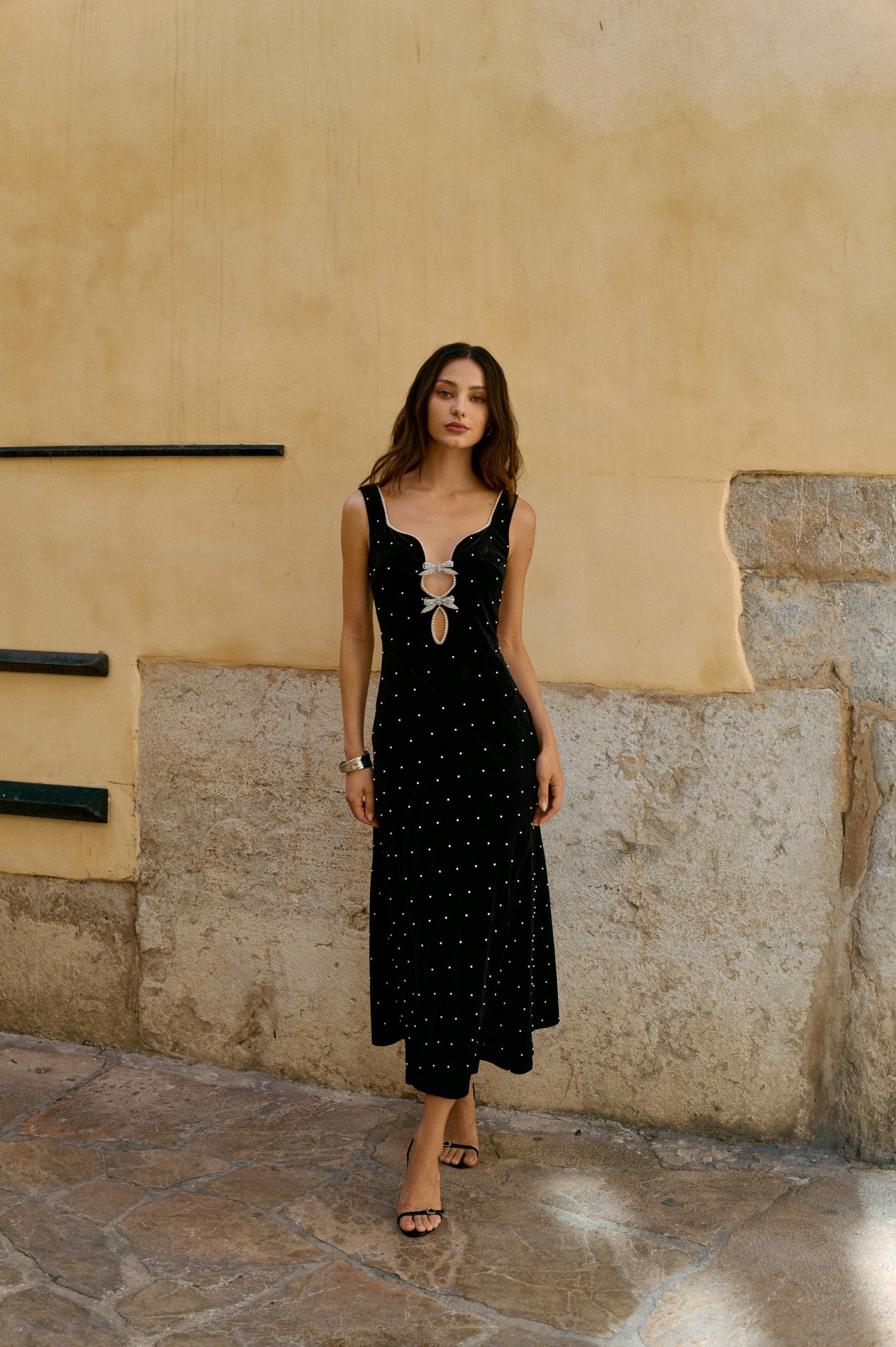 Navy velvet evening gown with pearl embellishments, sculpted neckline, and elongating front cutout
