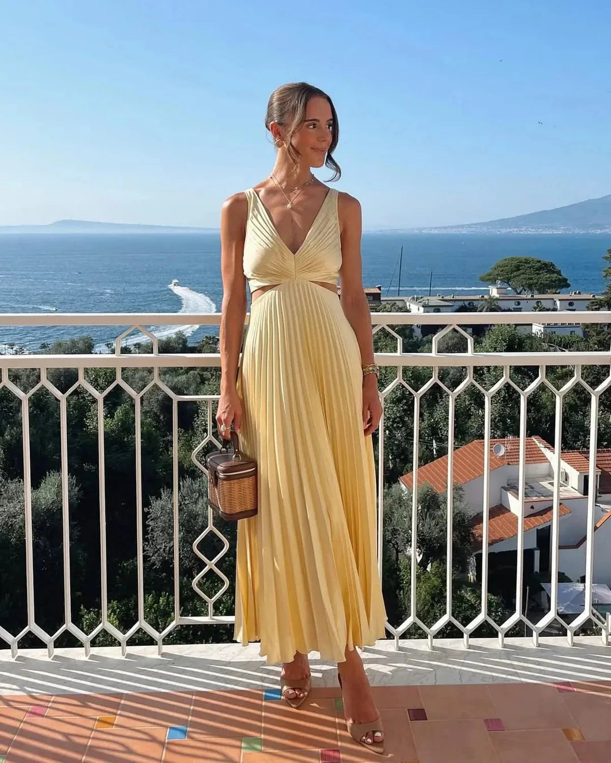 Yellow pleated maxi dress with V-neck, waist cutout, and fluid skirt for women