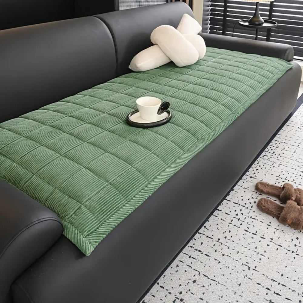 Quilted sofa cover with non-slip backing, pet-friendly protector in neutral tones with textured pattern