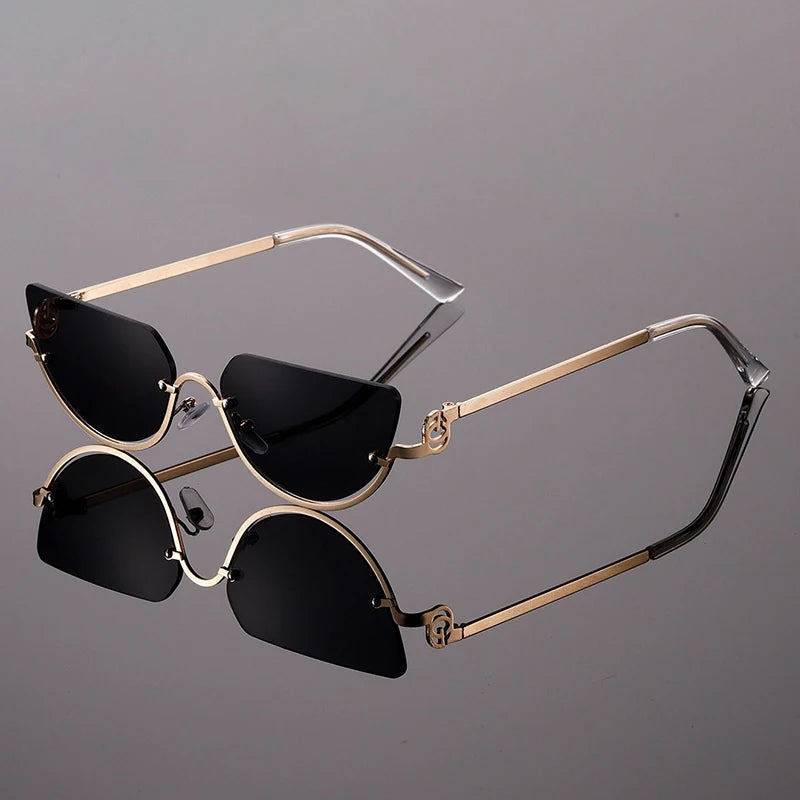 Black cat-eye sunglasses with sculptural lenses, gold-tone temples, and UV400 protection for women