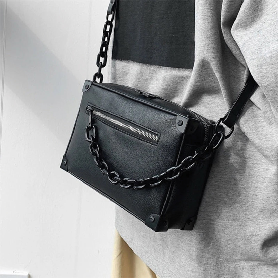 Black compact square crossbody satchel with detachable chain strap and polished envelope closure