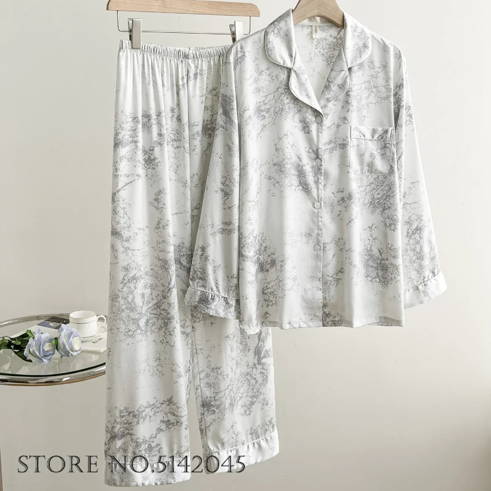 Women's floral satin pajama set in soft pastel tones, relaxed silhouette with breathable silky fabric