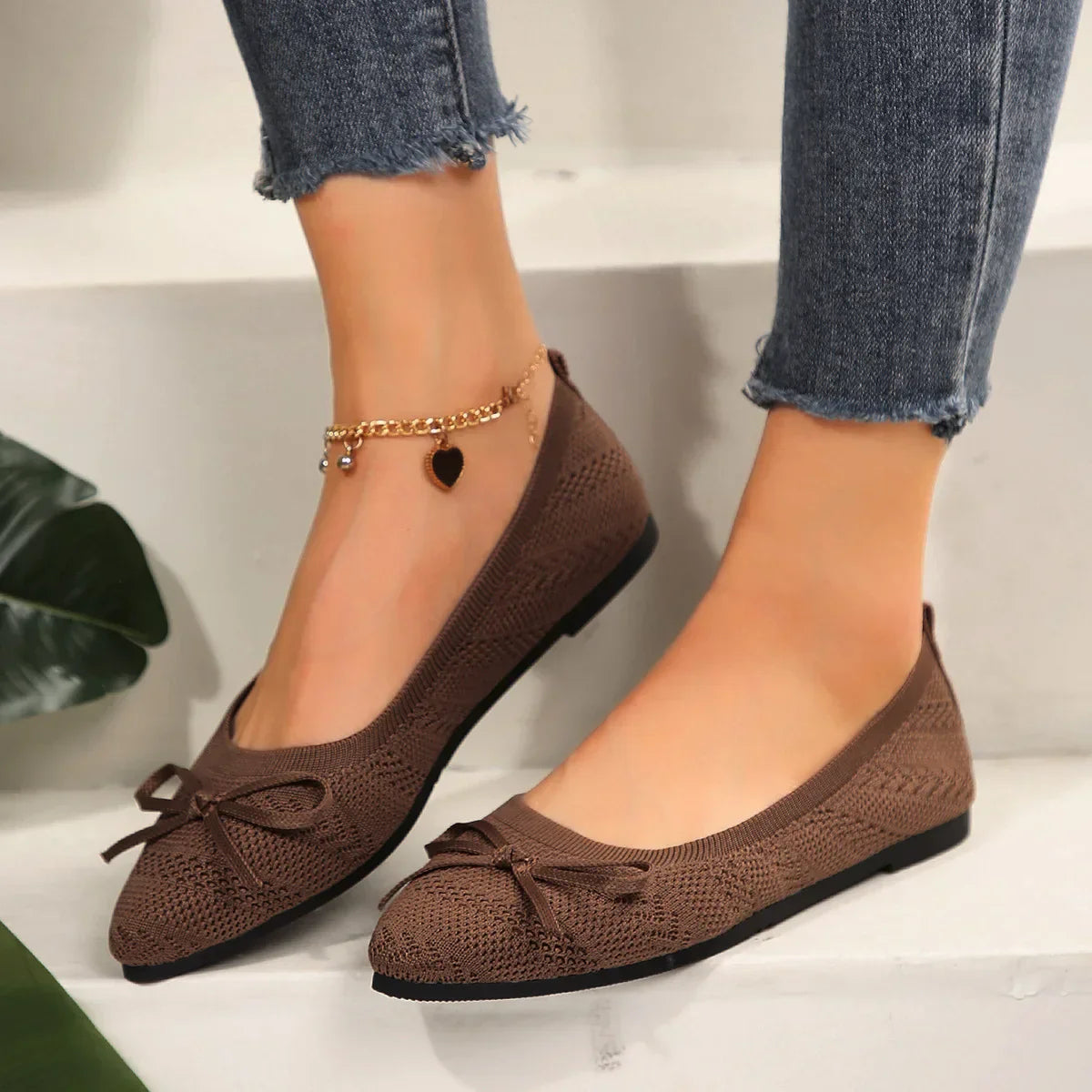 Women's lightweight breathable knit flats with playful tassel bow detail in neutral tones