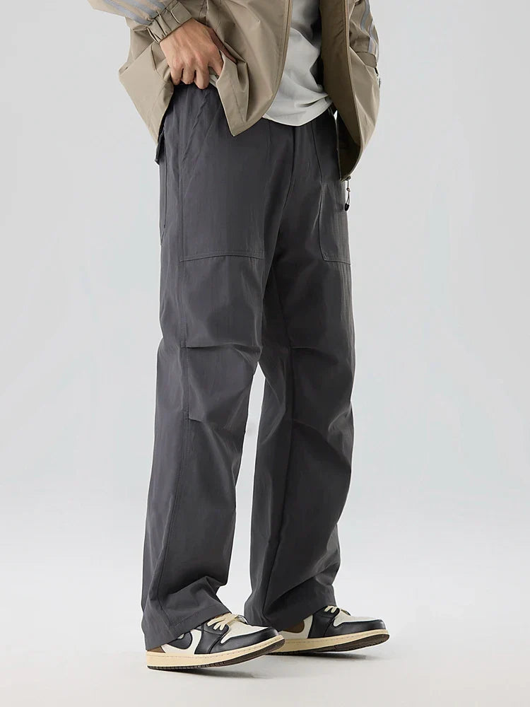 Men's olive green water-resistant nylon cargo pants with grid weave texture and deep utility pockets