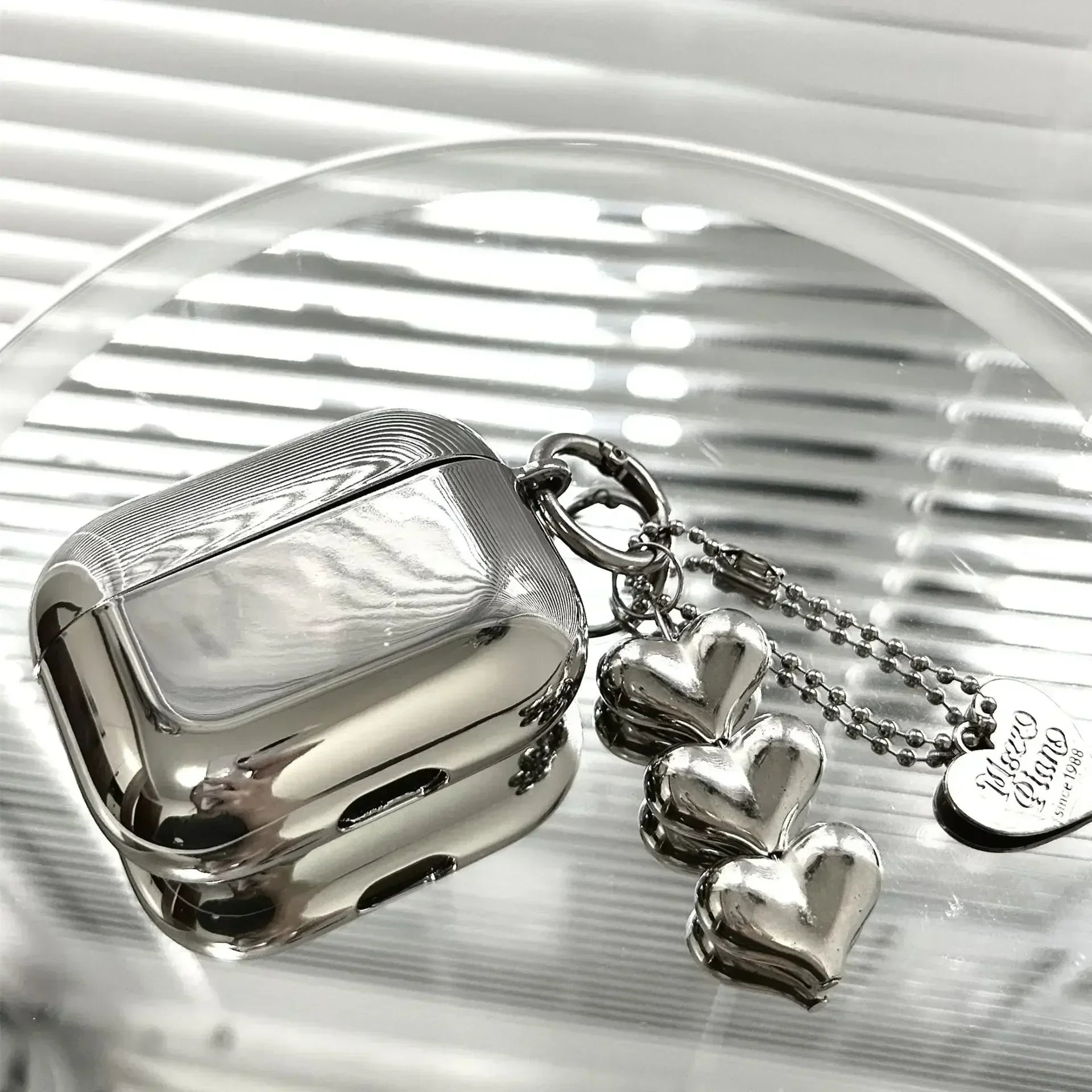 Electroplated steel-finish AirPods case with detachable heart charm futuristic metallic snap-on design