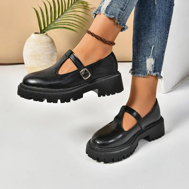 Women's black chunky platform shoe with classic buckle strap and retro-inspired rugged rubber sole