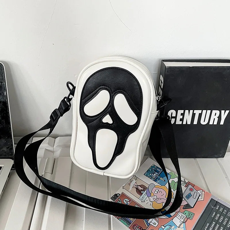 Bold black leather crossbody bag for women with graphic face motif and secure zip closure