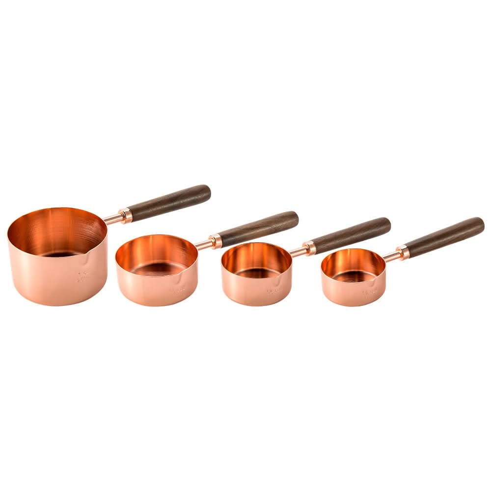 Gold-toned metal measuring cup set with wood handles, engraved markings, elegant kitchen tool
