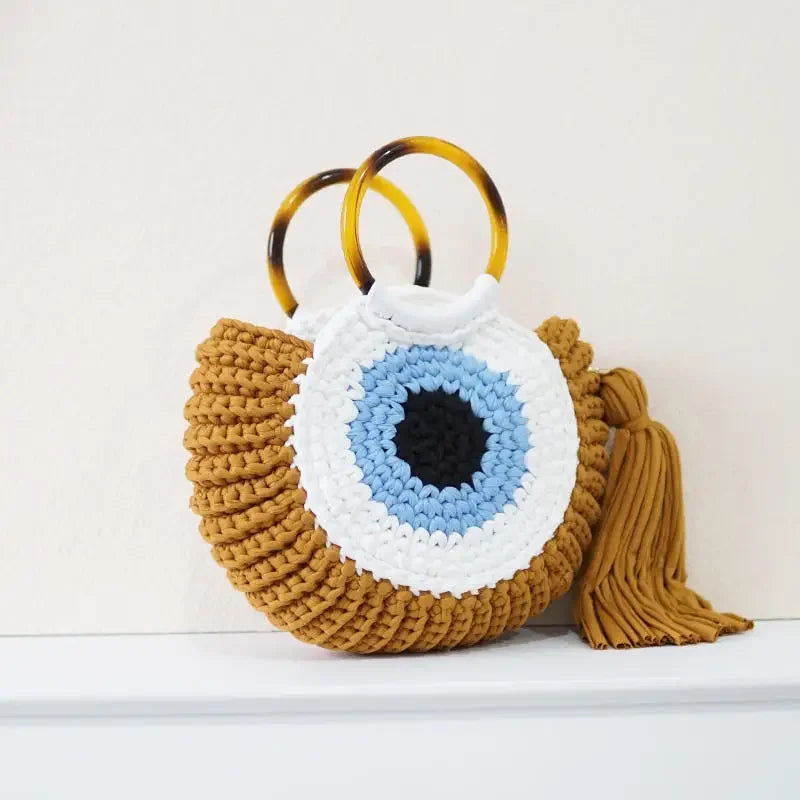 Handwoven evil eye mini clutch bag in blue talisman motif, compact boho-chic everyday accessory