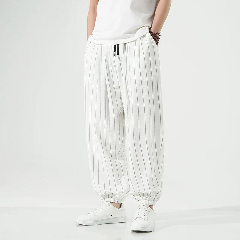 Men's relaxed-fit white pinstripe cotton trousers with elastic waistband and refined striped detailing