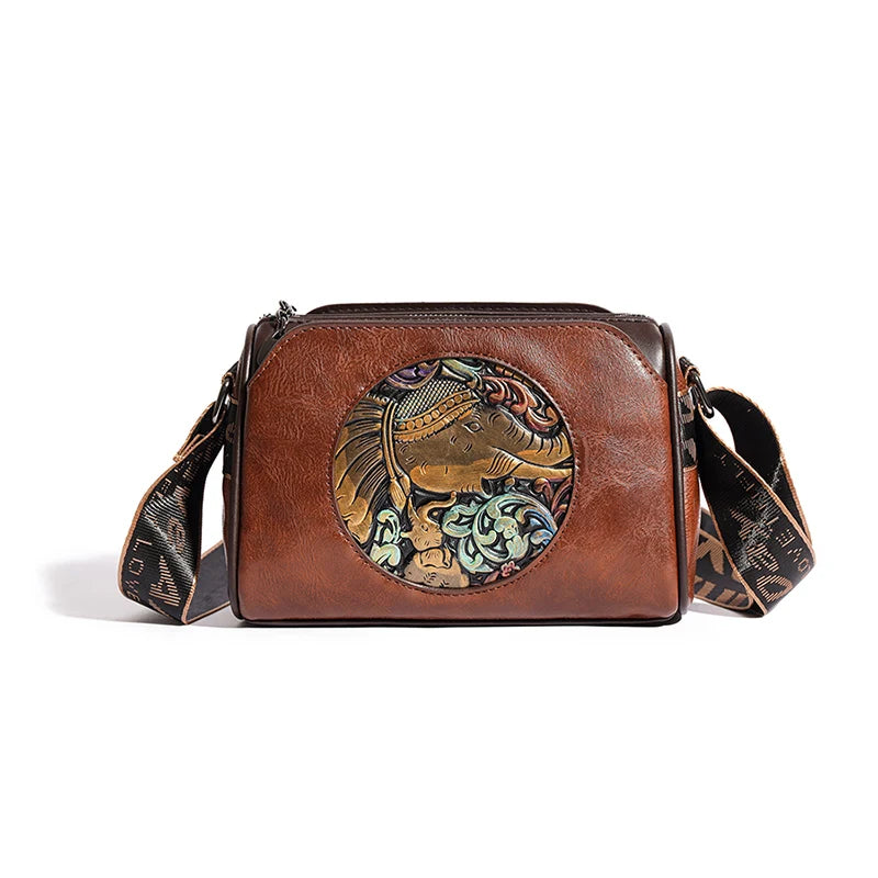 Brown leather shoulder bag with embossed circular elephant motif, blending artisan craftsmanship with everyday style