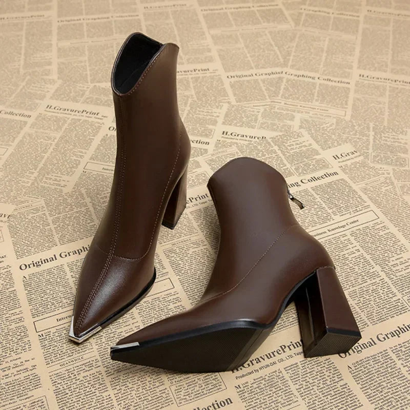 Women's black faux leather Chelsea ankle boot with sleek chrome toe tip and elastic side panels