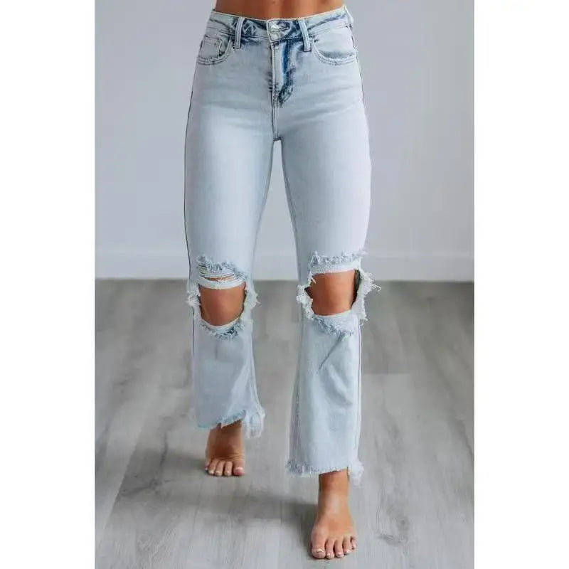 Women's high-rise skinny jeans in blue stretch denim with ripped distressed detailing and raw hem