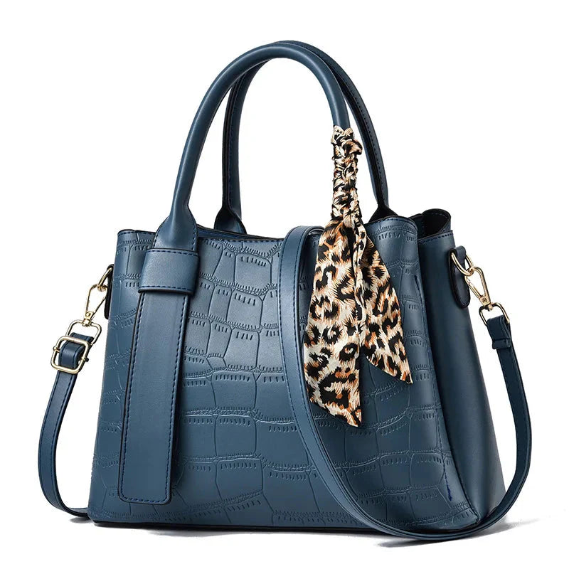 Structured women's black embossed leather tote bag with elegant texture and versatile top handles