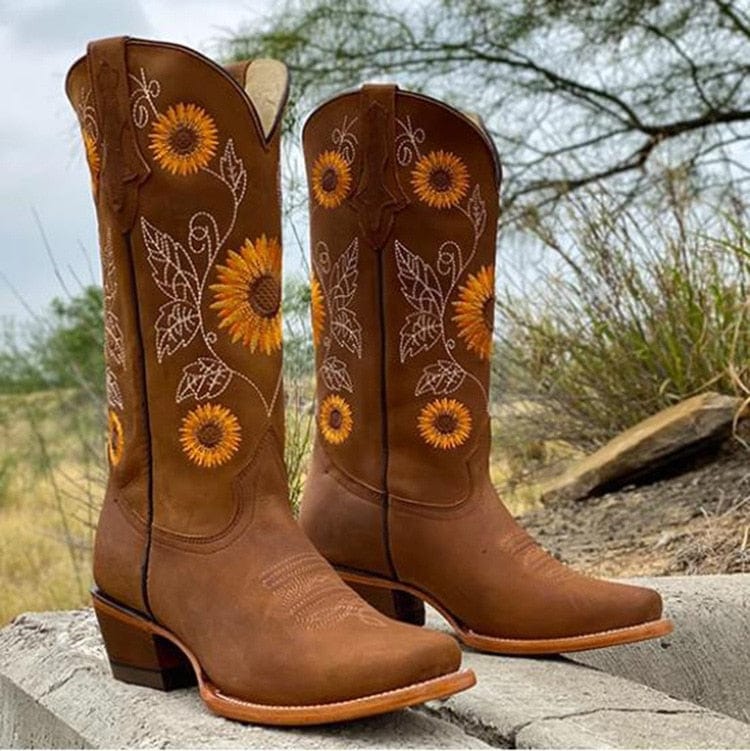 Women's tan cowboy boots with intricate sunflower embroidery, bold western rodeo style pull-on silhouette