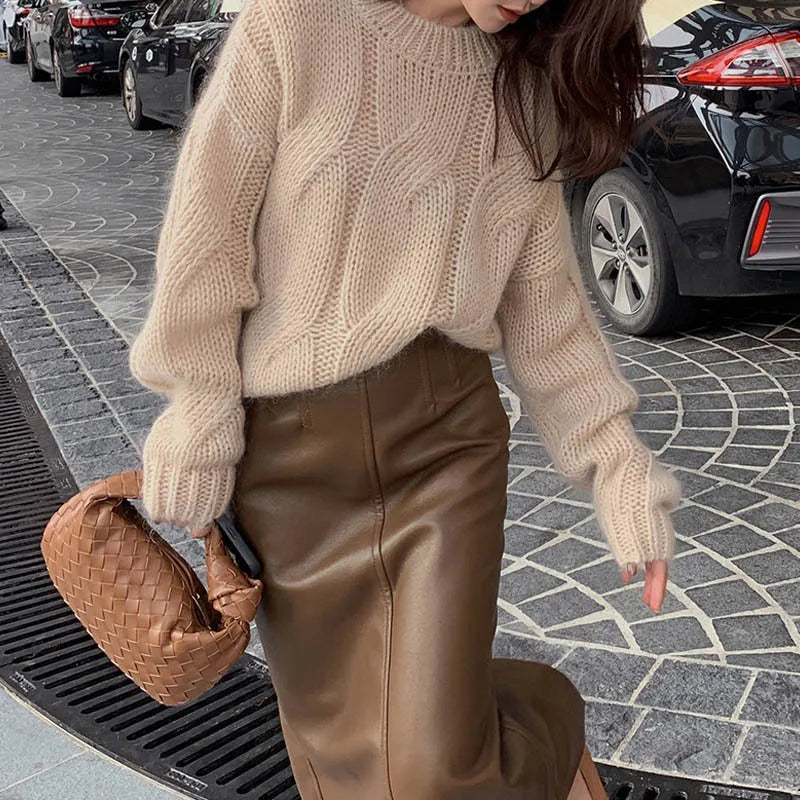 Women's oversized cable knit sweater in cozy wool texture with long sleeves and relaxed silhouette