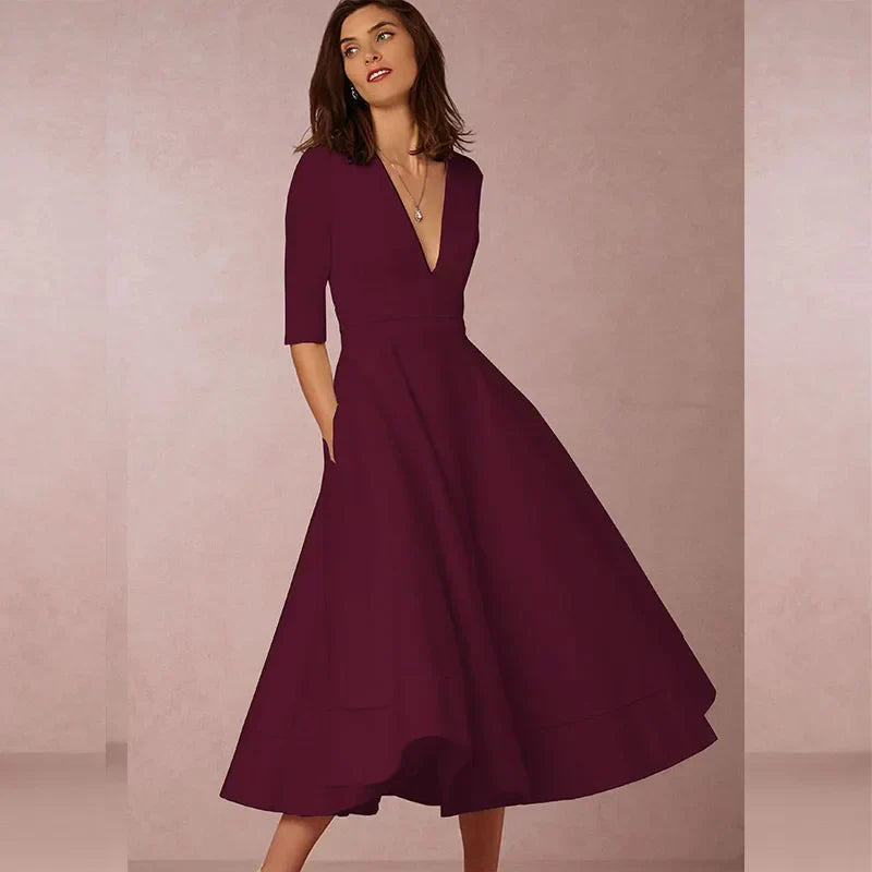 Elegant black A-line midi dress with deep V-neck, three-quarter sleeves, and textured luxurious fabric