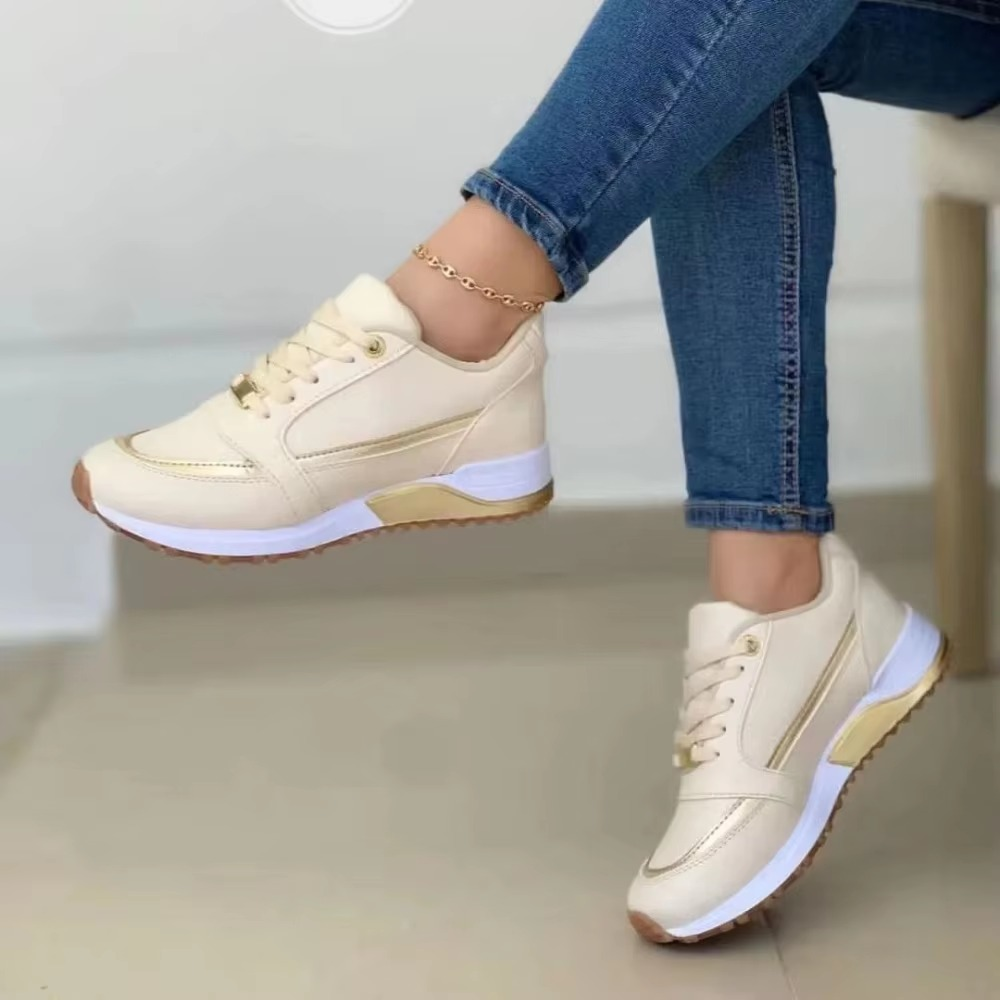 White casual fashion sneakers with round toe, thick sole, and gold stripe accent for everyday style