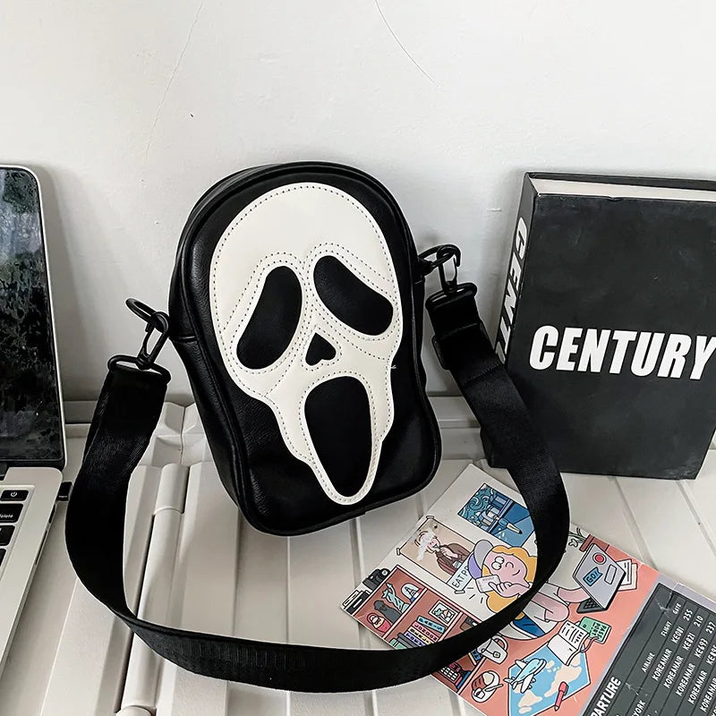 Bold black leather crossbody bag for women with graphic face motif and secure zip closure
