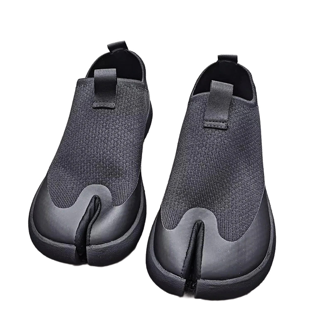 Black minimalist slip-on shoes with bold split-toe tabi silhouette for modern casual wear