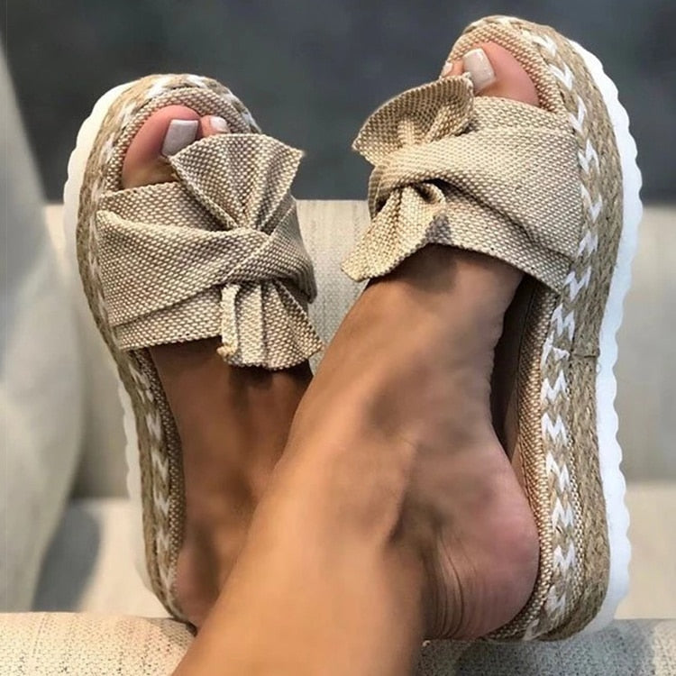 Women's yellow platform slides with braided sole and oversized bow, vibrant summer footwear