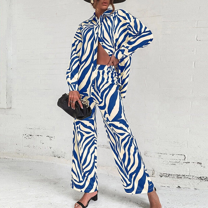 Women's elegant two-piece blouse set with vibrant abstract printed pants, modern chic silhouette