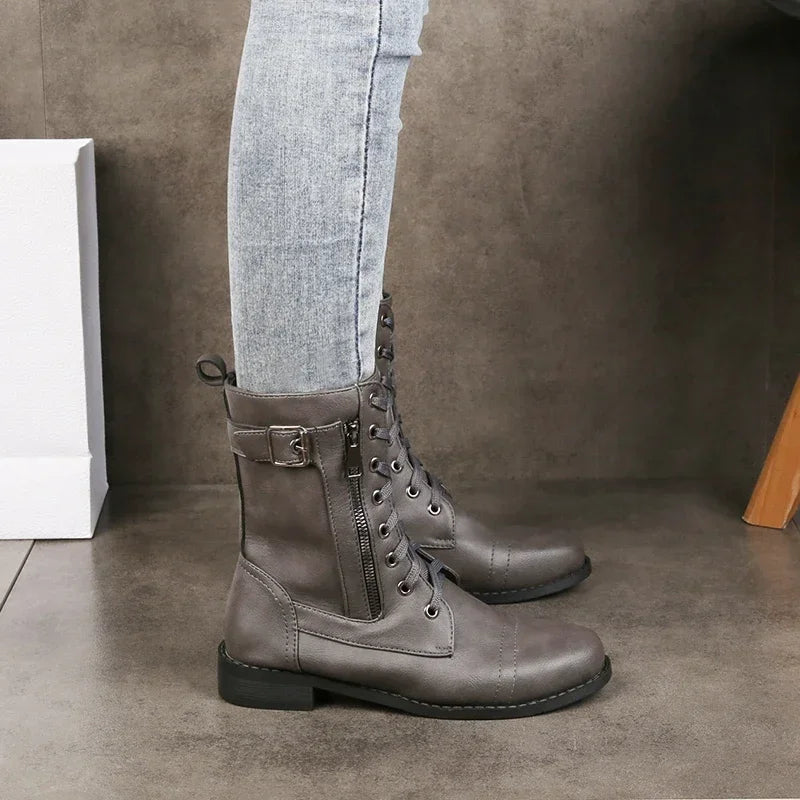 Women's black synthetic leather mid-calf moto boot with bold buckle accents, lace-and-zip closure